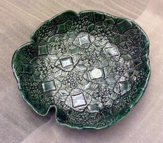 green platter with stamped design and wavy edges