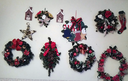 Wall displays:  six litttle wreaths using artificial coniferous branches and red ribbons and balls. Also flat wall or door hangings, like a snowman in front of a cartoo housefront, a star, a stocking...etc.