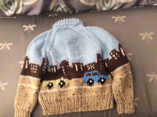 the back side of the sweater with the city scene