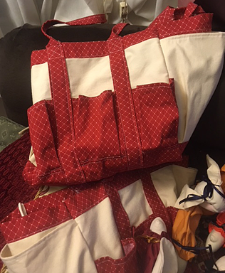 Two canvas bags with red-print trim and pockets.