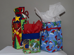 This photo shows three cloth bags, sewn into open-top bags with attached yarn ribbons.