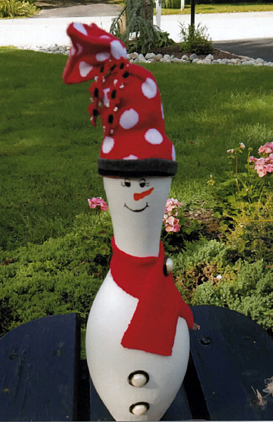funny snowman shaped like a bowling pin with cap and scarf
