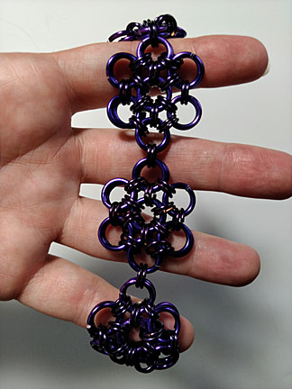 bracelet: entertwined circles making flower designs-dark metal