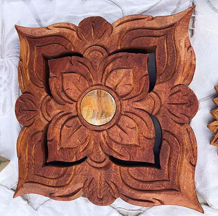 A round solid wood carving (12 inch?) with a small mirror (4 inches) in the center.