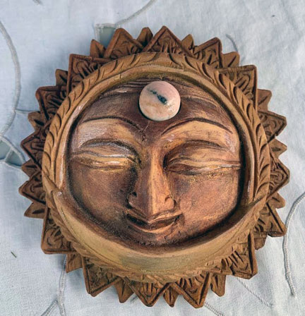 These next two pictures are close-ups of items seen in the last picture. This is a carving, probably 12inches diameter, of a sun with a face in solid wood.