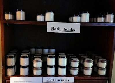 Bookshelf with jars of 'Bath Soaks' and 'Sugar Scrubs'.