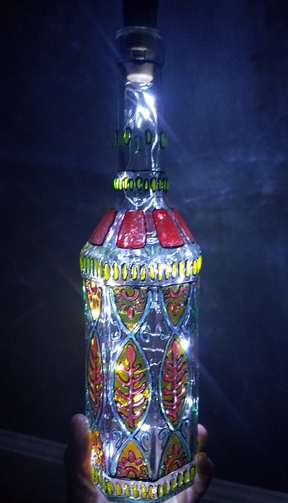 A tall glass bottle has been decorated ornately and beautifully.