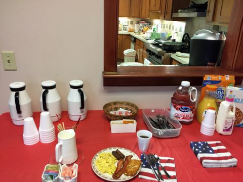 The serving table laden with food and breakfast beverages